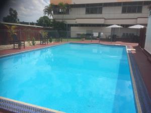 
a swimming pool with a blue and white swimming pool at Ambassador Motel in Rockhampton
