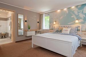 a bedroom with a white bed and a large window at Villa-Meehr in Bantikow