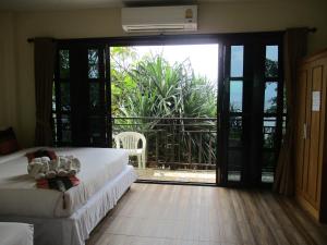 1 Schlafzimmer mit 2 Betten und einer großen Glasschiebetür in der Unterkunft Phi Phi Green House & Sunsky Hostel in Ko Phi Phi