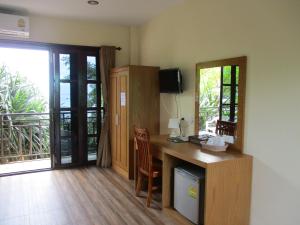 a room with a desk with a chair and a window at Phi Phi Green House & Sunsky Hostel in Phi Phi Islands