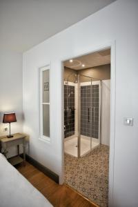 Schlafzimmer mit einer Glastür, die zu einer Dusche führt in der Unterkunft Hôtel Henri IV in Nérac