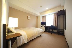 広島市にあるパークサイドホテル広島 平和記念公園前のベッドとデスクが備わるホテルルームです。