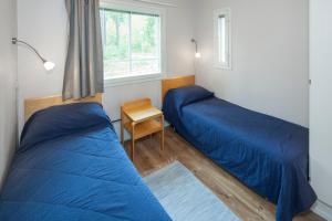 a bedroom with two beds and a window at Holiday Club Punkaharju Cottages in Kulennoinen