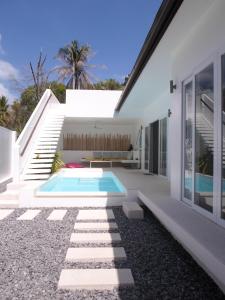 a white house with a swimming pool and stairs at Chuan Chom Villas in Lamai