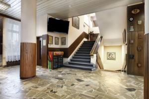 a lobby with stairs and a flat screen tv at Hotel Dom Marynarza in Gdynia