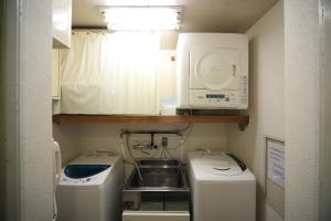 a small kitchen with a sink and a microwave at Hotel Park Side Hiroshima Peace Park in Hiroshima
