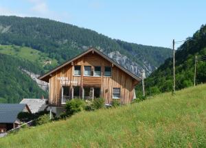 ein Holzhaus an der Seite eines Hügels in der Unterkunft Gästehaus Lutz in Mellau