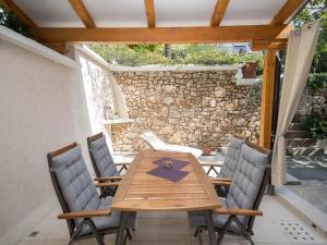 Une table et des chaises en bois sont disponibles sur la terrasse. dans l'établissement Apartments LATINO, à Crikvenica