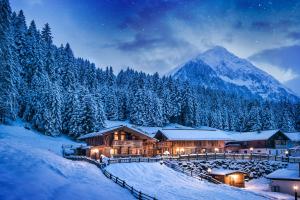domek w śniegu w nocy z górą w obiekcie Gletscher-Chalet Stubai w Neustift im Stubaital