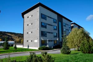 a large apartment building on a street with trees at Holiday Club Tahko Spa Apartments in Tahkovuori