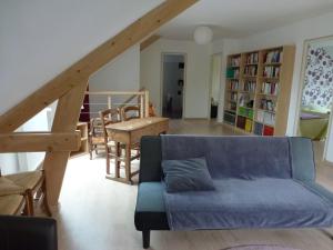 a living room with a blue couch and a table at La maison verte in Agon Coutainville