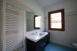 y baño con lavabo y espejo. en Villetta Pastura, en Cissano