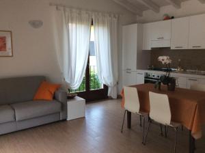 cocina y sala de estar con mesa y sofá en Villetta Pastura, en Cissano