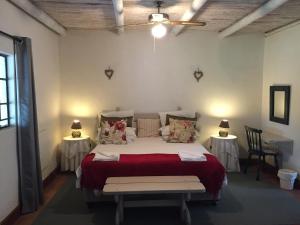 a bedroom with a large bed with two tables at Franschhoek Country Cottages in Franschhoek