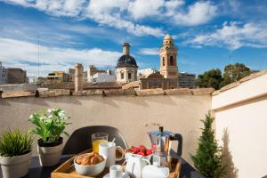 a table with food on a balcony with a view of a city at SingularStays Botanico29 in Valencia