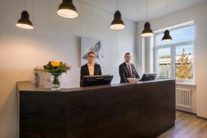 two people are standing at a reception desk at Hotel Ruf in Pforzheim