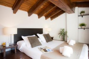 1 dormitorio con cama blanca grande y techo de madera en SingularStays Botanico29, en Valencia