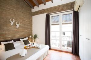 a bedroom with a large bed and a large window at SingularStays Botanico29 in Valencia