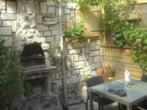 a patio with a stone wall with a fireplace and a table at B & B Kostelijk in Boekelo