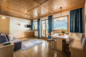 a living room with a couch and a table at Residence Bondì in Colfosco