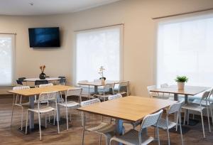 a room with tables and chairs and a flat screen tv at B&B HOTEL Figueres in Figueres