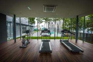 a gym with three treadmills and a large window at Dorsett Residences Bukit Bintang @Dorsett Kuala Lumpur in Kuala Lumpur