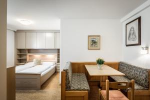 una camera ospedaliera con un letto e un tavolo di Residence Bondì a Colfosco