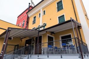 ein Gebäude mit Tischen und Stühlen auf einem Balkon in der Unterkunft Hotel Blue Ribbon in Vercelli