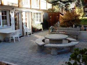 een patio met 2 banken en een tafel bij Haus Alpenperle in Saas-Almagell