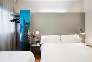 1 dormitorio con 2 camas blancas y pared azul en B&B HOTEL Girona 2 en Salt