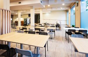 eine leere Cafeteria mit Tischen und Stühlen in der Unterkunft B&B HOTEL Girona 2 in Salt
