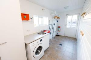 eine Waschküche mit einem Waschbecken und einer Waschmaschine in der Unterkunft Vaðlahof in Akureyri