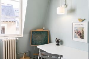 een klaslokaal met een schoolbord en een tafel en een radiator bij Ty Paradis by Cocoonr in Rennes