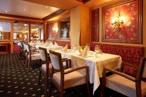 une rangée de tables dans un restaurant avec des nappes blanches dans l'établissement Göbels Landhotel, à Willingen