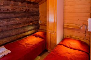 um quarto com 2 camas numa parede de madeira em Holiday Club Ruka Cottages em Oivanki