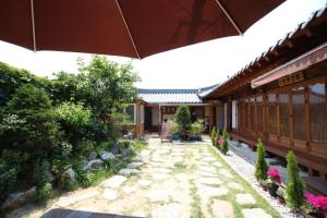 a courtyard of a building with an umbrella at Sori poonggyung in Jeonju