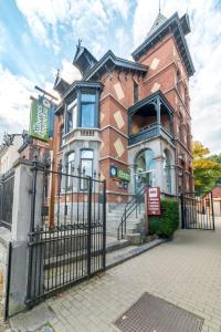 a large brick building with a gate in front of it at Auberge de Jeunesse de Namur in Namur