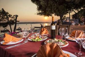 a table with plates of food and a bottle of wine at Mobile Home Heaven Biograd in Biograd na Moru