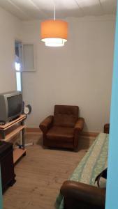 uma sala de estar com um sofá e uma televisão em Casa de Marvila em Santarém