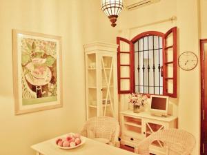 a dining room with a table and chairs and a clock at Apartamento Centro Judería in Seville