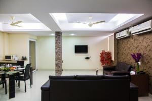 een woonkamer met 2 plafondventilatoren en een eetkamer bij Skyla Service Apartments - Gachibowli in Hyderabad