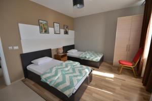 sypialnia z 2 łóżkami i czerwonym krzesłem w obiekcie Hotel Veri w mieście Peshkopi