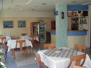 a restaurant with tables and chairs in a room at Hotel Astoria in Burgas