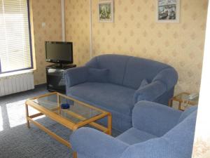 a living room with a blue couch and a coffee table at Hotel Astoria in Burgas +1 photo