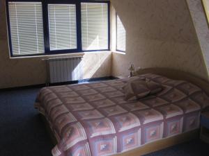 a bedroom with a bed in a room with windows at Hotel Astoria in Burgas