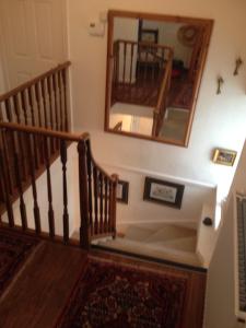 a hallway with a staircase with a mirror and a mirror at Southford House (Room Only) in Dartmouth