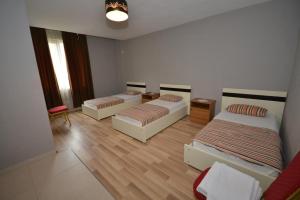 a room with two beds and a couch in it at Hotel Veri in Peshkopi