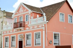 um edifício cor-de-rosa com uma varanda por cima em Pousada Solar da Lapa em Lapa