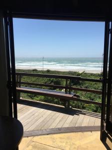 a bench on a porch looking out at the beach at Residencial Casa Santinho in Florianópolis