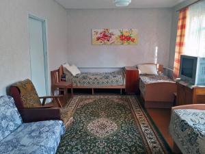 a living room with two beds and a tv at Guest house Elena in Kaji-Say